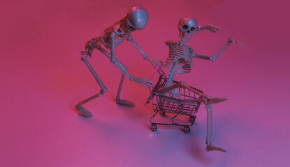 Fototapeta na wymiar Scary funny skeletons with shopping trolley in pink blue gradient neon light