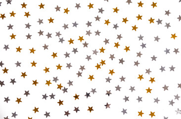Golden and silver stars glitter on a white isolated background. Festive holiday backdrop.