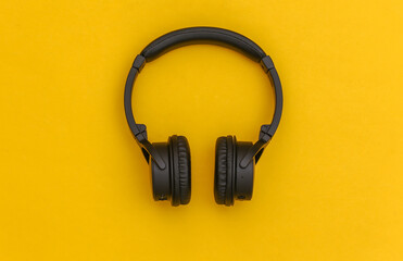 Wireless stereo headphones on yellow background. Top view