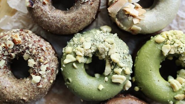 Donuts in flat lay.Doughnuts prepared for lunch meal in cafe.Fresh bakery products cooked with natural sweetener,glazed with pistachio & cocoa.Sweet pastry product shot directly from above on table