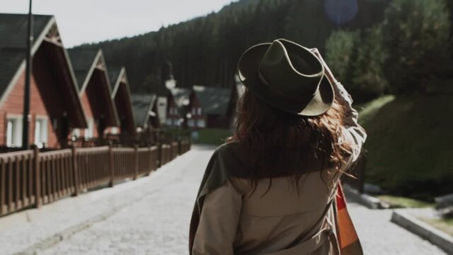 hipster girl in a green hat and cloak walks the streets of Switzerland.Woman In Hat Enjoying Sun