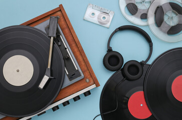 Retro vinyl record player with records, audio magnetic reel, audio cassette and stereo headphones...