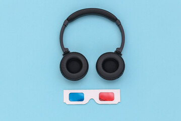 3d glasses and stereo headphones on blue background. Top view. Flat lay
