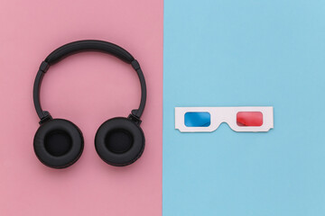 3d glasses and stereo headphones on blue pink background. Top view. Flat lay