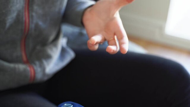 Close up of young woman hands with glucose meter. Blood testing at home. Metabolic syndrome