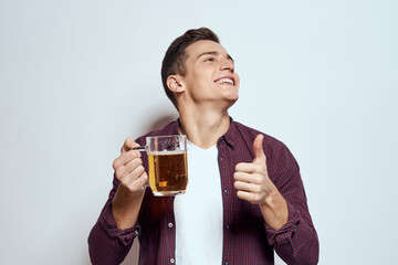 Drunk man with a mug of beer vacation alcohol lifestyle in a red shirt emotions light background