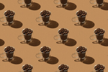 Pattern: glass cups with coffee beans with hard shadow on brown background
