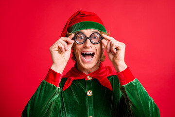 Portrait of crazy astonished little elf look into geek speks on x-mas christmas discounts isolated...