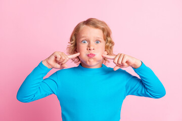 Photo of little child puff cheeks indicate fingers look camera wear blue turtleneck isolated pastel...
