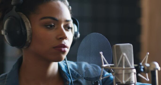 Sound record industry. African american female singer recording new song at professional room