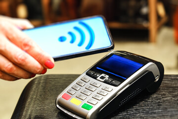 Payment by smartphone in the payment terminal. Electronic money. Mobile banking. Shopping complex