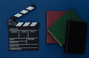 Fototapeta na wymiar Film clapper board and books on classic blue background. Movie by book. Cinema industry, entertainment. Top view