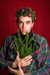attractive man in a plaid shirt on a red background hair like a christmas tree christmas mood copyspace