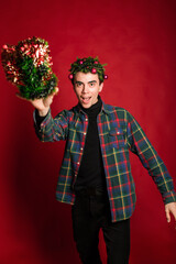 attractive man in a plaid shirt on a red background hair like a christmas tree christmas mood copyspace