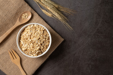 Oat flakes in white bowl top view. Concept healthy eating, dieting and vegetarian food.