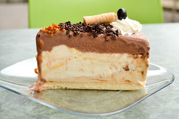 Piece of delicious layered souffle cake with plazma cookies and chocolate