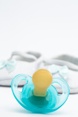 Blue soother in front of baby booties