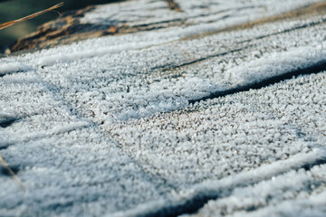 Frozen icy old boards in the snow close up