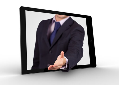 Businessman Reaching Out From Tablet For Handshake