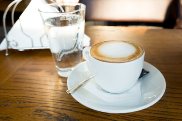 Coffee time - chasing the sun in cup of excellent cappuccino coffee