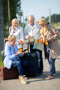 Group of positive senior people looking at map on traveling journey during pandemic.COVID-19 travel in the New Normal.