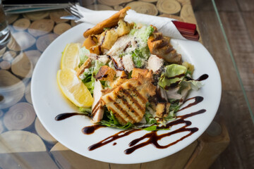 Caesar salad with roasted chicken breast, parmesan cheese, lettuce leaf, cherry tomatoes, cheese sauce and toasted bread