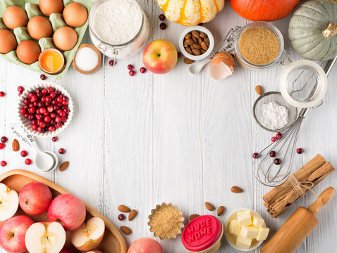 Ingredients for autumn winter baking - flour, sugar, eggs, apples, pumpkins and spices.