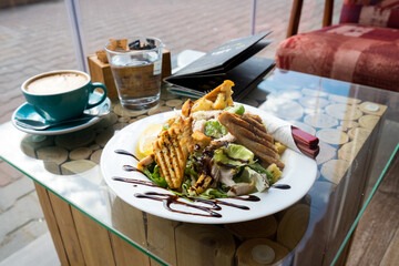 Caesar salad with roasted chicken breast, parmesan cheese, lettuce leaf, cherry tomatoes, cheese sauce and toasted bread