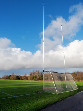 Irish National sports training with goal posts for Gaelic sports camogie, hurling, irish football, rugby and soccer. Green grass and blue cloudy sky