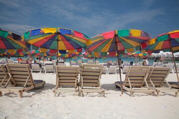 Tourists swimming and Snorkeling at beach with resort outdoor sunshade and chairs on the tropical island in Phuket, Thailand. 