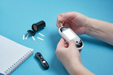 Diabetes checking blood sugar level. Woman using lancelet and glucometer