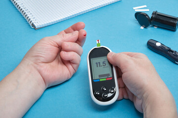 Diabetes checking blood sugar level. Woman using lancelet and glucometer