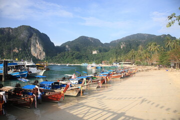 Fototapeta na wymiar View of Phi Phi islands main arrival port Tonsai bay with pier view and ferry boats in Phuket, Krabi province, Thailand 