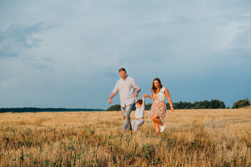 Happy family in the field evening light of a sun.