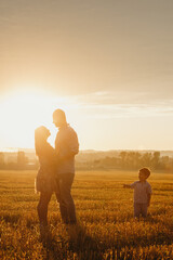 Happy family in the field evening light of a sun.