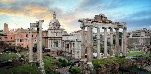 Obraz na płótnie Canvas Panoramic view of Ruins of Roman Forum in Rome, Italy, also known as Foro di Cesare, or Forum of Caesar, on a bright summer day. on Capitolium hill in Roma at sunset. Panorama