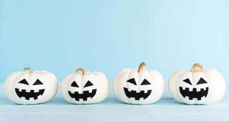 White ghost pumpkin on pastel blue background. Halloween decoration concept.