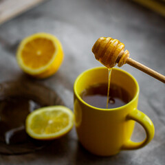 black tea with honey, lemon on a gray background