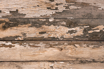 Texture of old painted brown wooden wall with peeled paint and cracks close up