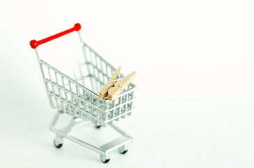 Miniature shopping cart model containing wooden clothespin scene represent laundry online service concept related idea.