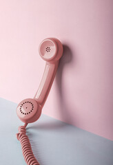 pink vintage telephone on blue and pink background