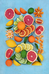 Large collection of citrus fruit with oranges, lemons, limes & grapefruit high in antioxidants, anthocyanins, lycopene, fibre & vitamin c. Immune boosting health care concept. On mottled blue.  
