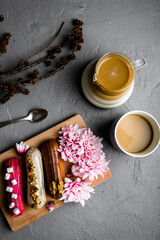 Top view of delicious breakfast on with coffee and sweets on gray textured background.