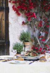 テーブルのハーブ料理と赤い花