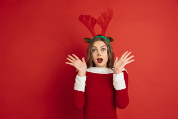 Astonished. Greetingcard. Concept of Christmas, 2021 New Year's, winter mood, holidays. Copyspace for ad, postcard. Beautiful caucasian woman with long hair like Santa's Reindeer catching giftbox.