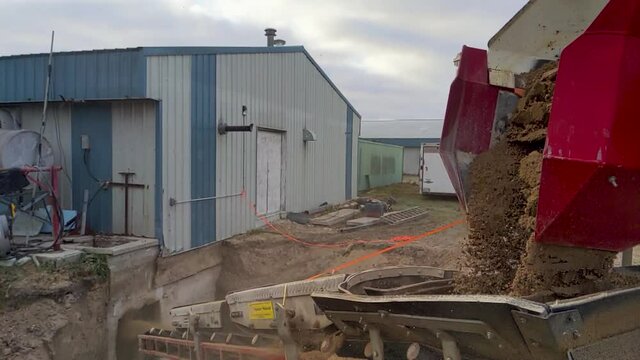 SLO MO Gravel being unloaded from a piece of specialized equipment at the construction site.  Stone slinger thrower. 4k
