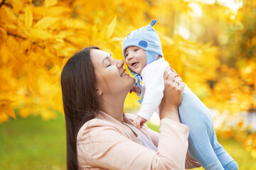 happy portraits of mom and baby in autumn park