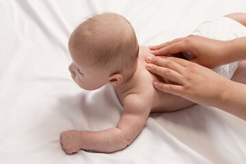 baby massage, close-up hands on baby back top view
