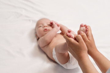 Obraz na płótnie Canvas baby foot massage, close-up of hands and foot of baby