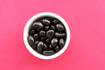 dark chocolate sweets on pink background